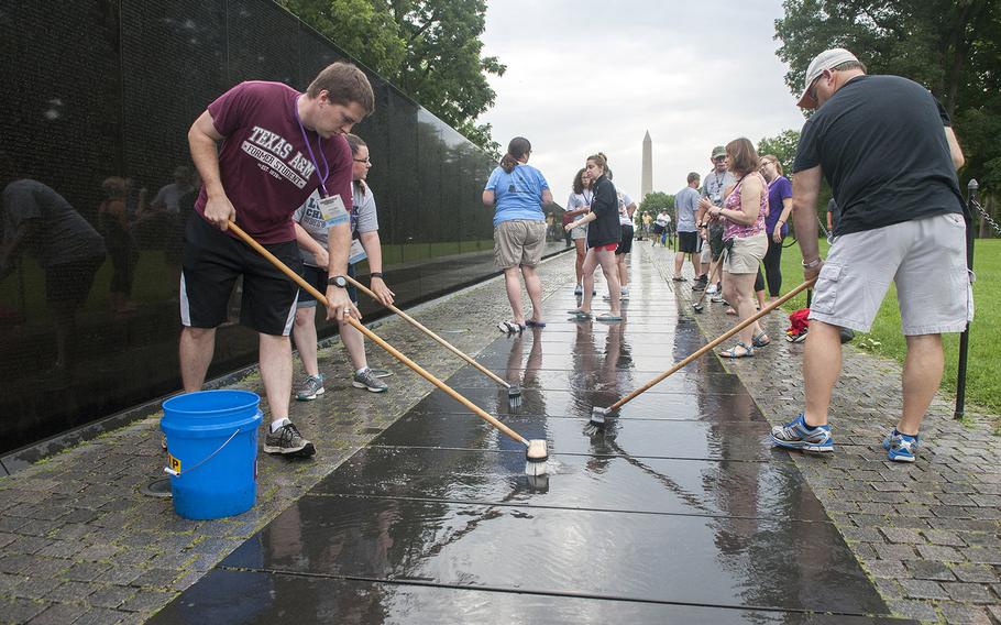 Volunteers scrub the walkway at the Vietnam Veterans Memorial Wall on June 20, 2015.