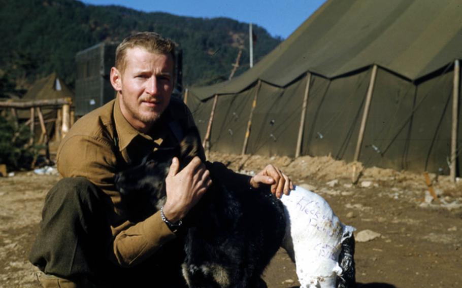 Frank Praytor poses with Mangy, a stray dog he found in 1953 while covering the Korean War as a Marine Corps combat correspondent.