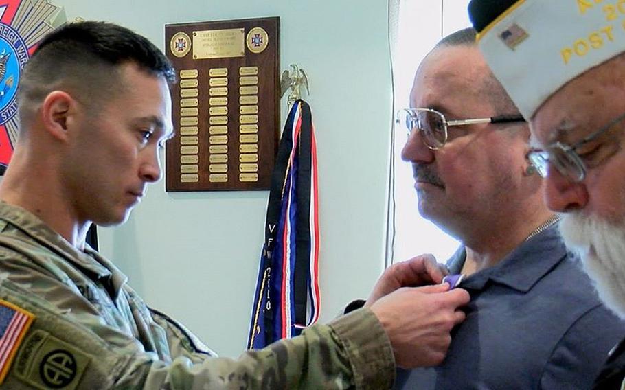 Command Sgt. Maj. Michael Carden of Carlisle Barracks in Pennsylvania pins a Purple Heart onto the lapel of David Ott, a retired National Guard combat medic who was wounded in Iraq in January 2006, as Rick Olson, VFW Post 477 commander, reads the award citation during a luncheon on Wednesday, Jan. 29, 2019.