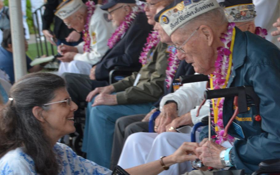 Flanked by fellow survivors of the 1941 attack on Pearl Harbor, Thomas Berg talks with his wife, Lesa Barnes, before the start of a commemoration of the event in Hawaii, Dec. 7, 2019.