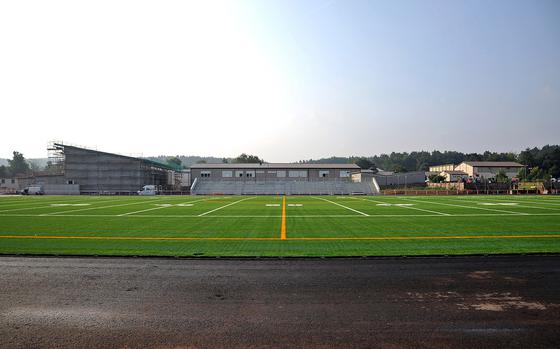 A view of the new Kaiserslautern High School stadium from the 50-yard line. Construction is progressing and should be ready for action in the spring. The artificial grass field will be surrounded by an eight-lane track. It will also have facilities for field events. Behind the visitors stands is Kaiserslautern Elementary School. At left it is a new multipurpose room that is under construction, and at far right is the high school gym.

