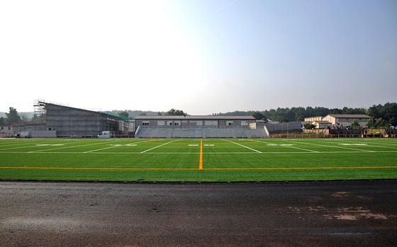 A view of the new Kaiserslautern High School stadium from the 50-yard line. Construction is progressing and should be ready for action in the spring. The artificial grass field will be surrounded by an eight-lane track. It will also have facilities for field events. Behind the visitors stands is Kaiserslautern Elementary School. At left it is a new multipurpose room that is under construction, and at far right is the high school gym.

