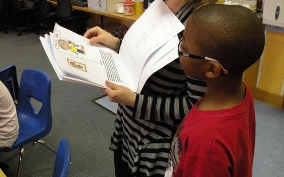 Teacher Karen Griffis reviews the book created by Torence Davis during a work session on March 24 at Feltwell Elementary School. The books were presented to the public at an authors' tea on April 6 and 7.