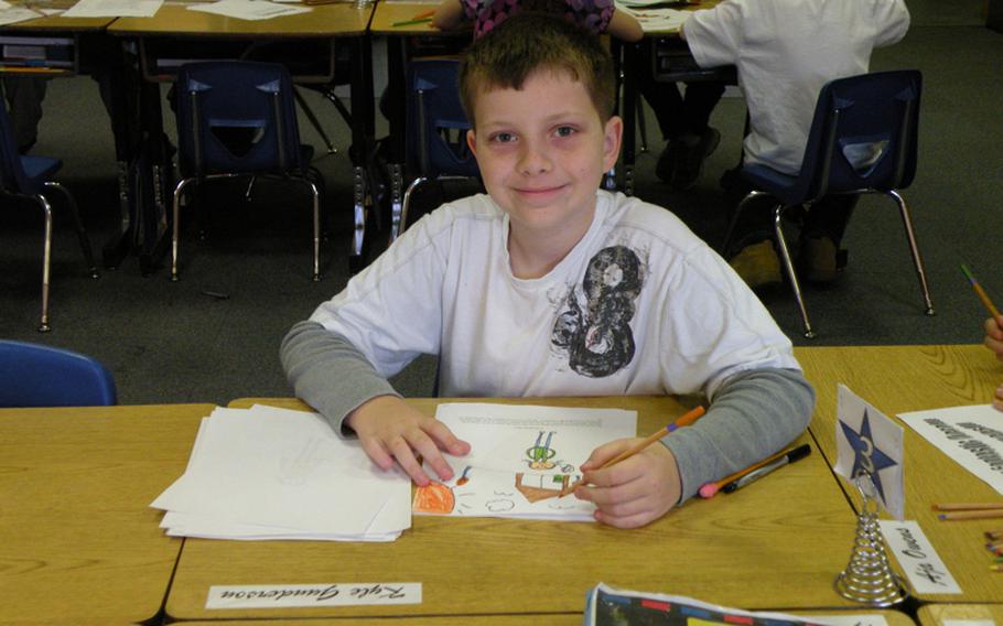 Kyle Gunderson takes a break from coloring a picture he drew while putting together a book about his local hero, Mandy Kumiyama, at Feltwell Elementary School in England. Twenty-two students from Karen Griffis' class held an authors tea, April 6 and 7, to publicly recognize their heroes and read their reports.