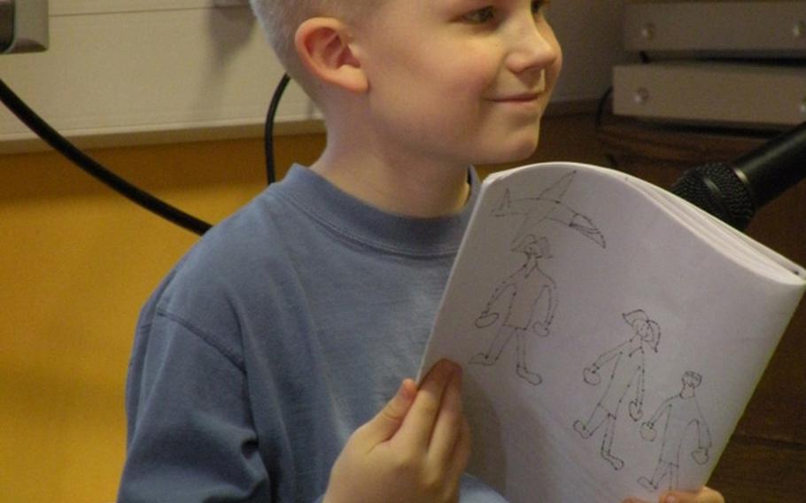 Adam Torkelson pauses from his reading to look over at his hero, his mother Debbie Torkelson, during an authors tea on April 7 in Karen Griffis' class at Feltwell Elementary School. Adam and 21 other students created books about their local heroes for a project that Griffis also organized in classrooms in Japan and the United States.