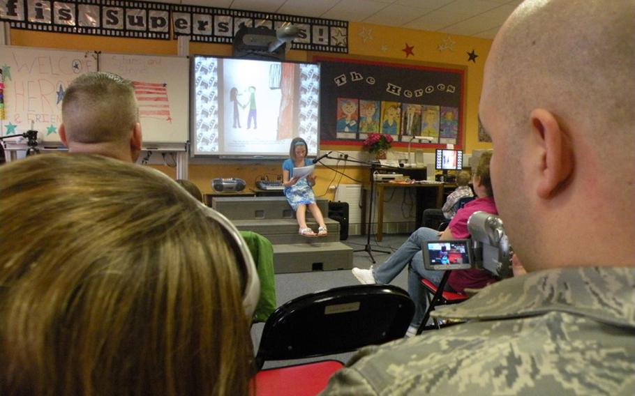 Alexis Kimes reads a story about her hero and father, Master Sgt. Gary Kimes  of the 351st Air Refueling Squadron at RAF Mildenhall, England, during an authors tea on April 7 in teacher Karen Griffis' class at Feltwell Elementary School.