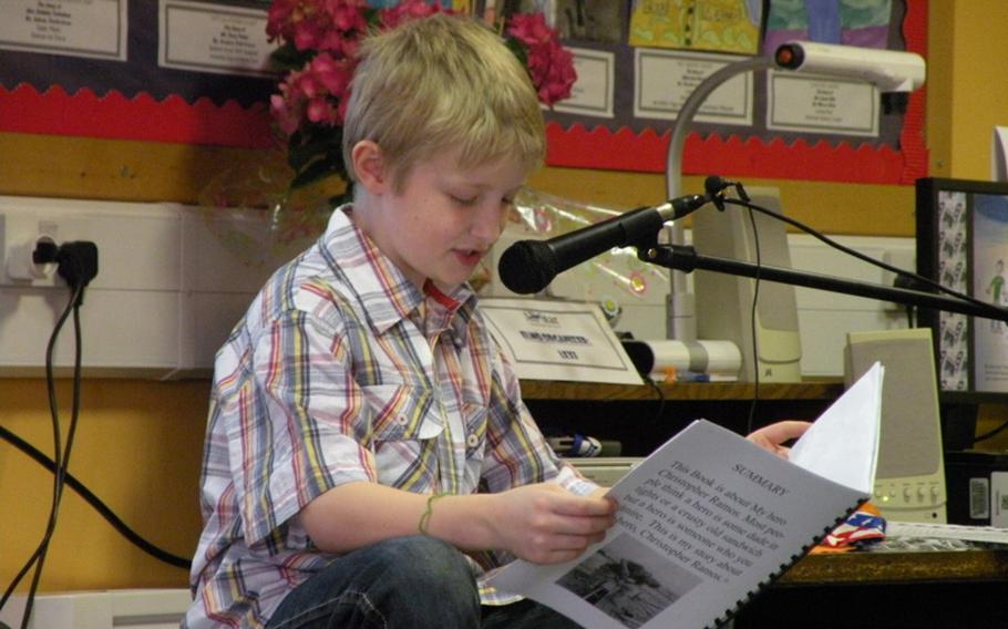 Eoin Ramos reads about his hero, his father Senior Master Sgt. Christopher Ramos from the 352nd Special Operations Support Squadron at RAF Mildenhall, during an April 7 authors tea in Karen Griffis' multiage third- and fourth-grade class at Feltwell Elementary School in England. Part of the page pictured reads, "Most people think a hero is some dude in tights or a crusty old sandwich but a hero is someone who you admire."