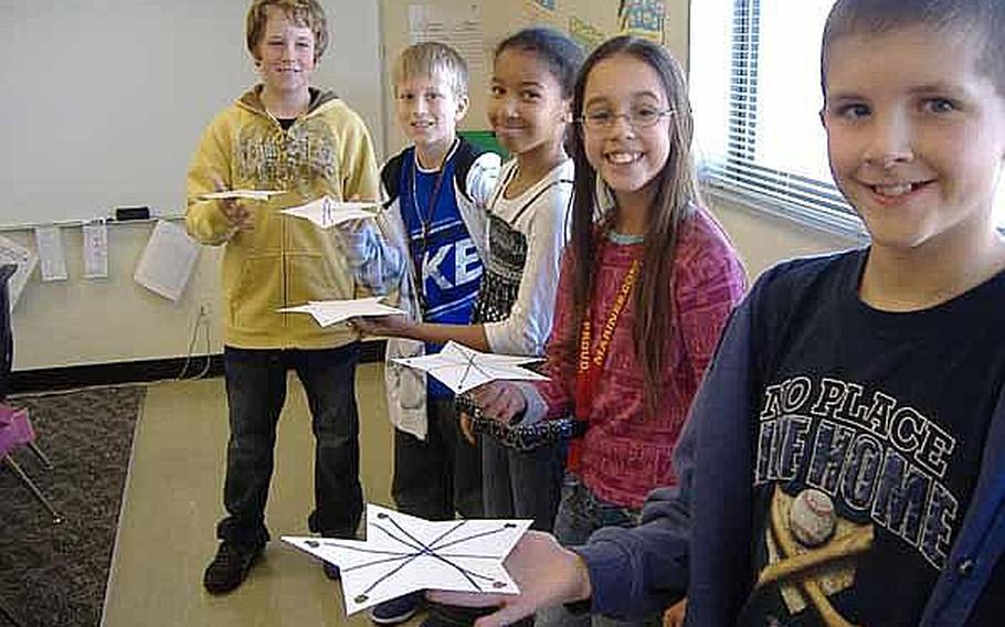From left, fifth-graders Max Taber, Dylan Herron, Serena Johnson, Kathiana McIntyre and Sam Terry pose for a picture while balancing stars on their fingers during an exercise about finding the center of balance in January at Kinser Elementary School on Okinawa. It was one of several mini-experiments their teacher Laurie Arensdorf arranged while the class built a game for NASA's 'Spaced Out Sports' contest. The fifth-graders finished second in the competition.