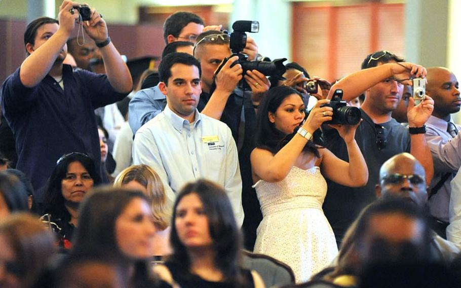 Family and friends take photos as the graduates receive their diplomas at the University of Maryland University College Europe commencement ceremony in Heidelberg on Saturday. School officials said they were expecting and audience of about 1,200 at the ceremony.