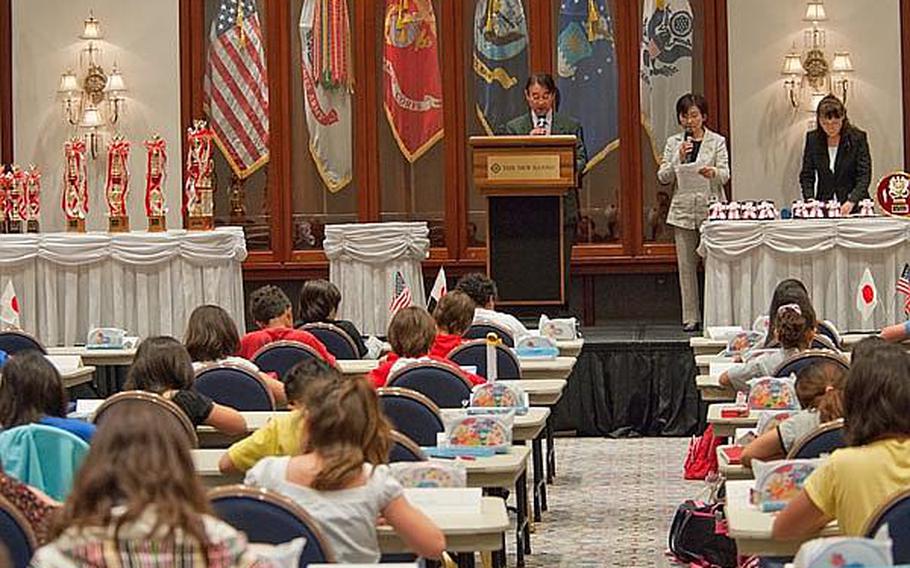 An announcer reads out math problems to a room full of students at the New Sanno Hotel in Tokyo for the 29th Kanto Area DODDS Soroban Contest.