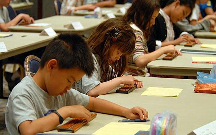 Kanto-area students work the beads on their sorobans during Wednesday's math contest at the New Sanno Hotel in Tokyo.