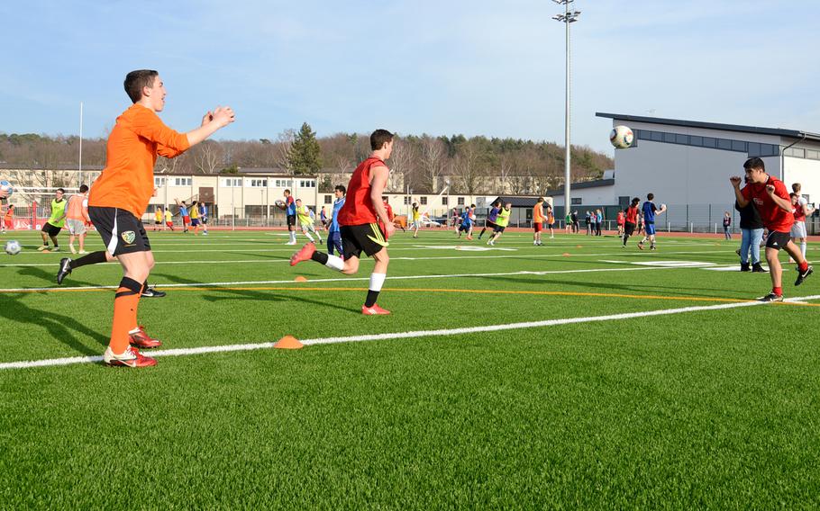 Kaiserslautern Raiders soccer players, foreground, and the track team, in the background practice on their new field as they prepare for the 2013 DODDS-Europe spring sports season. In the background at right is the newly constructed multipurpose room.